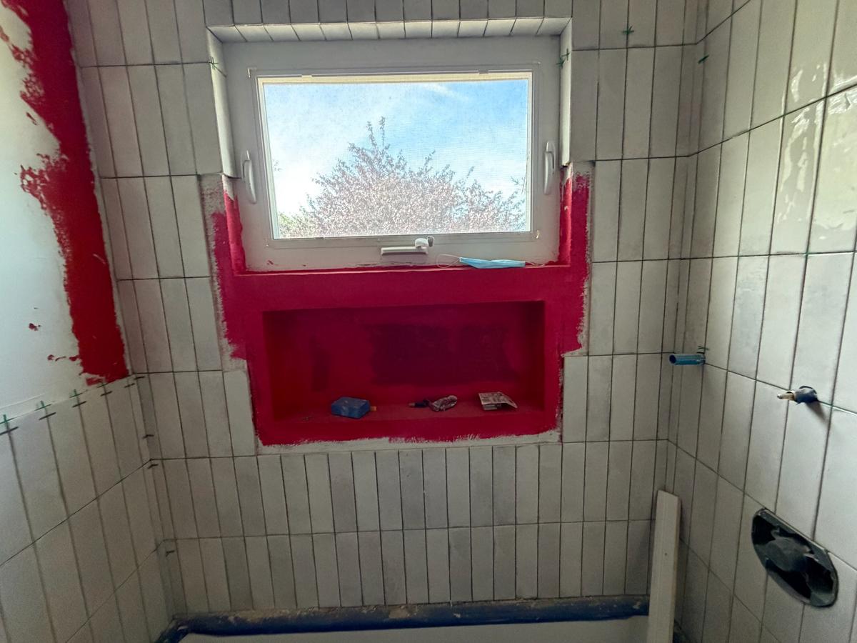 Tile surround with waterproofed niche below window