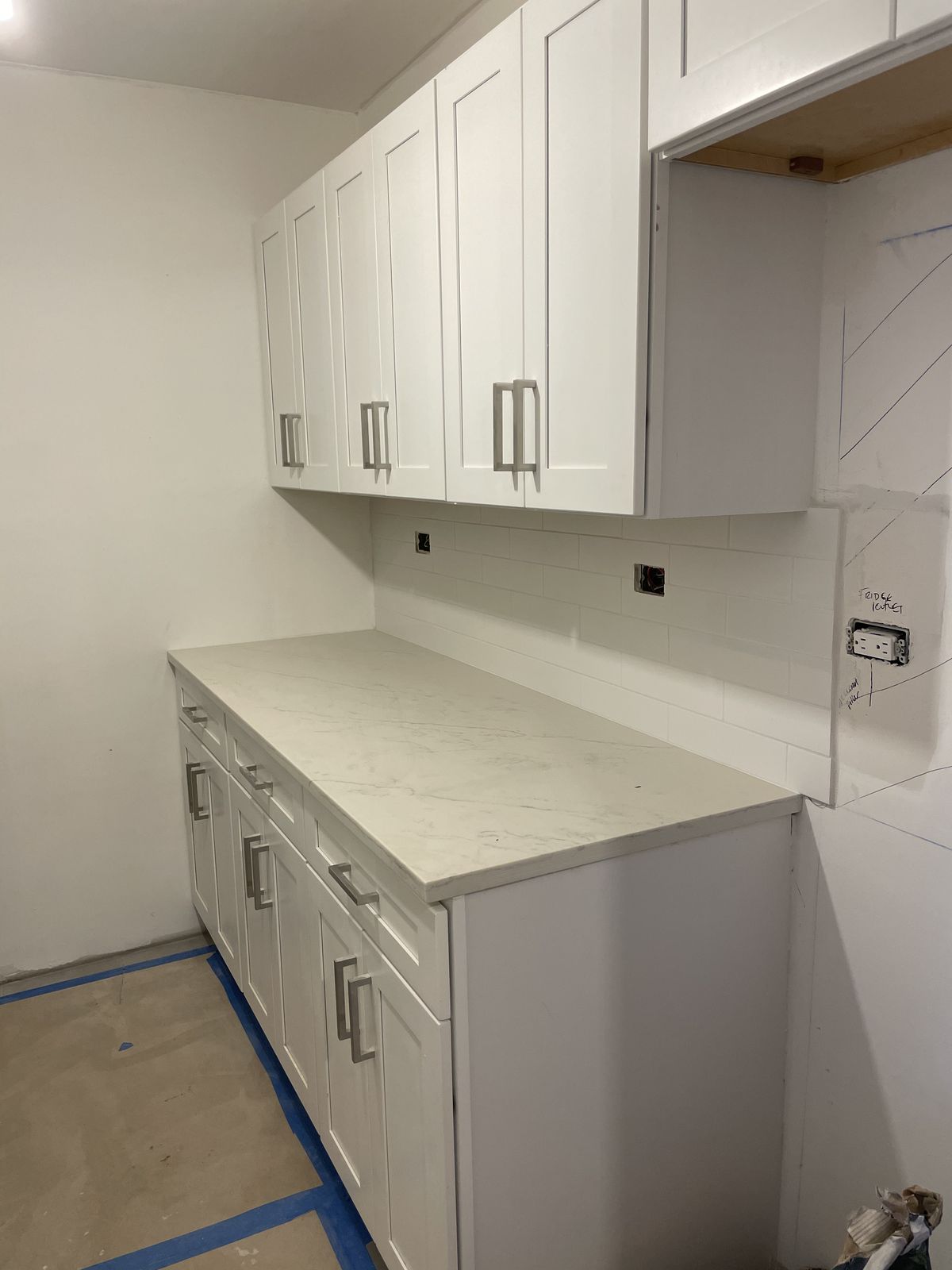 White marble countertop with subway tile backsplash on shaker cabinets