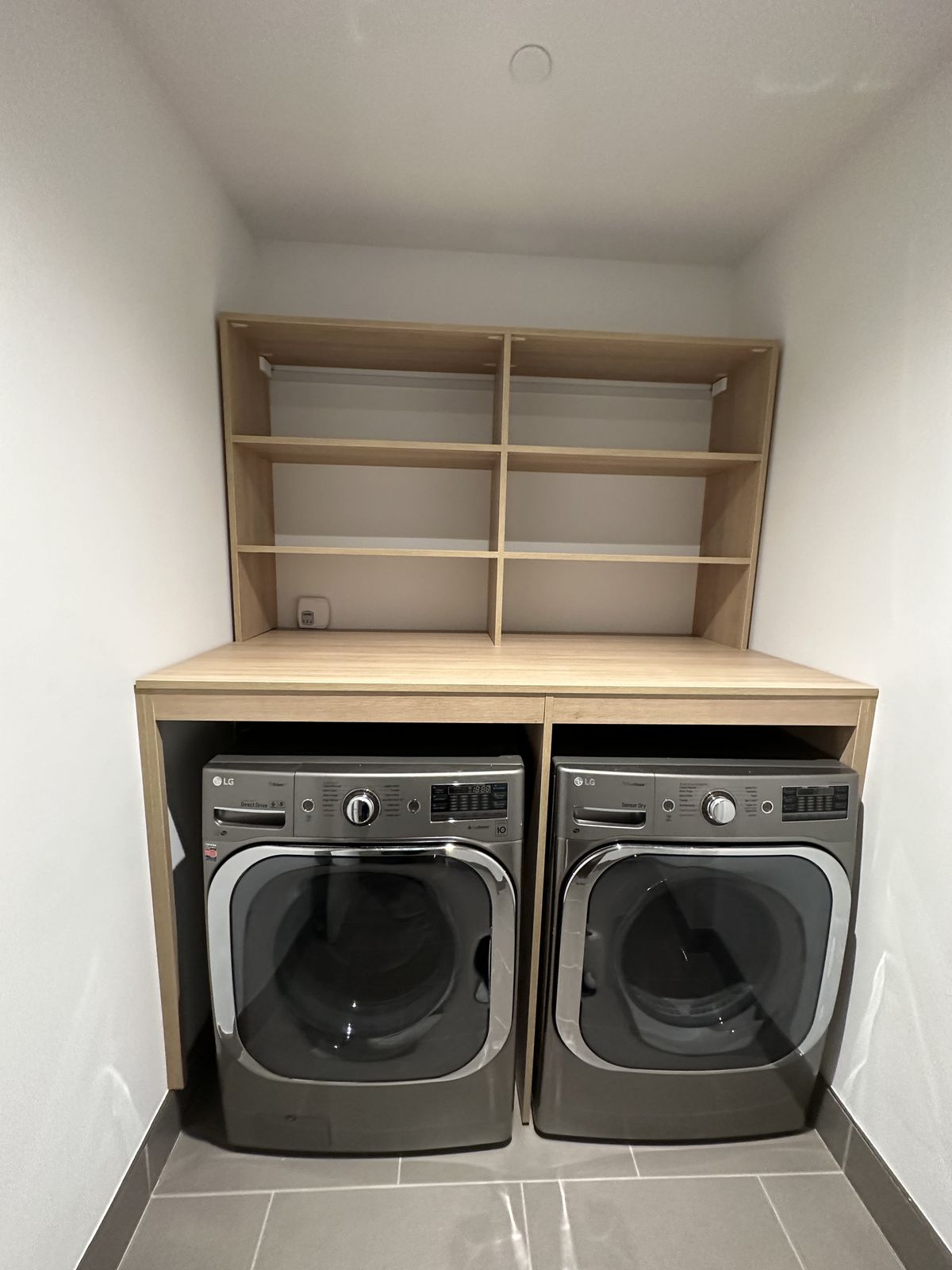 Custom laundry room built-in with countertop above washer-dryer