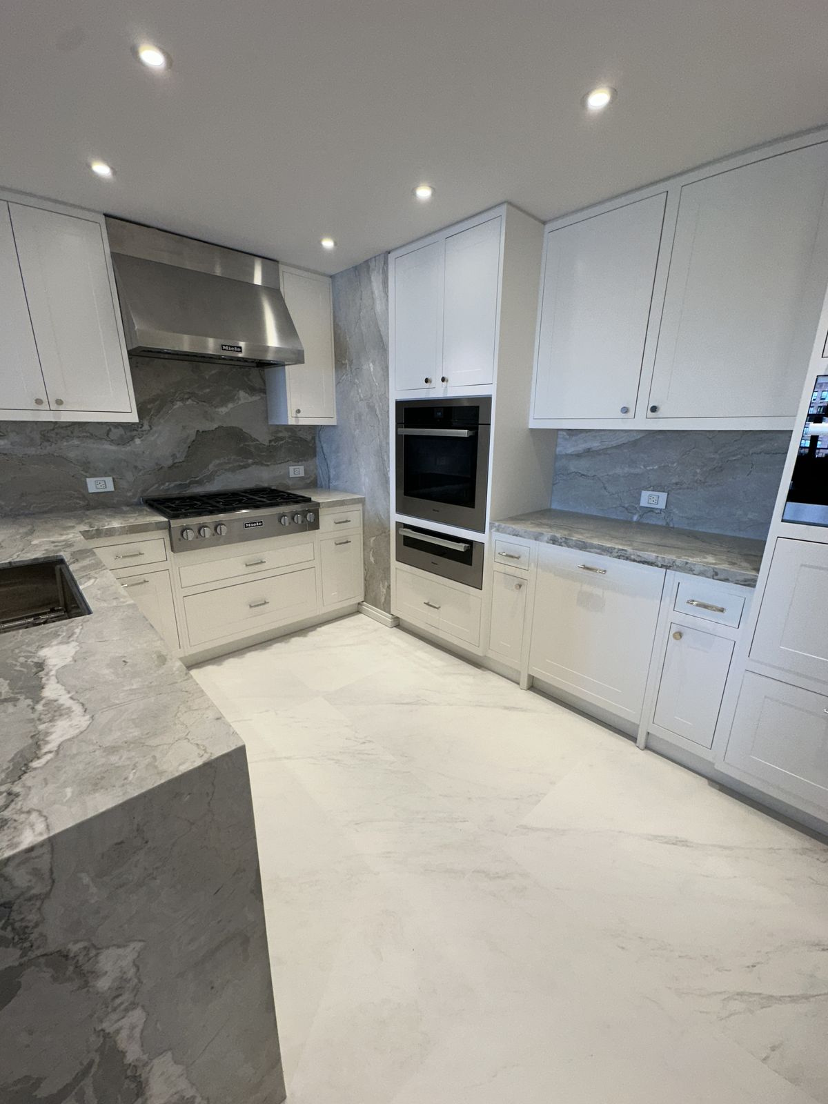 Kitchen island with custom millwork base and waterfall countertop