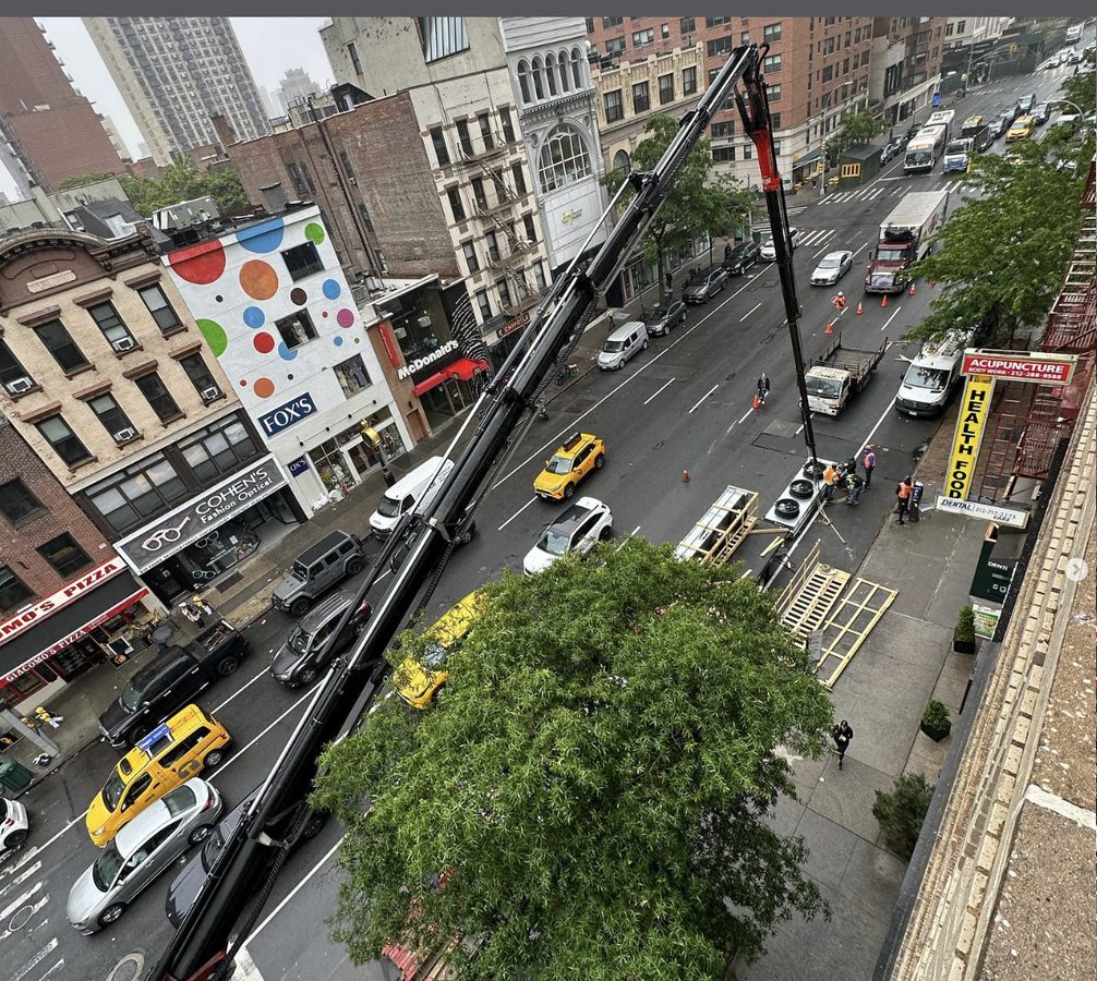 Crane rigging operation on 3rd Avenue in Manhattan for rooftop HVAC and steel delivery