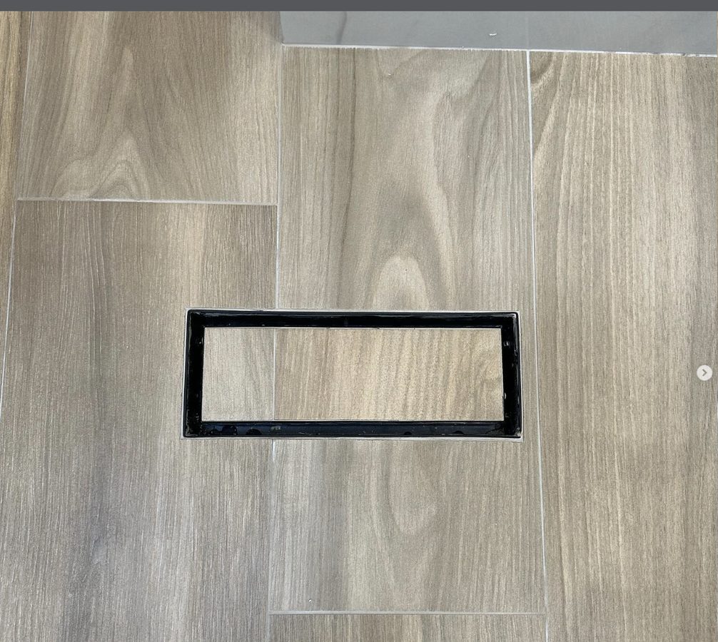 Wood-look tile flooring with seamless flush-mount HVAC vent in residential renovation