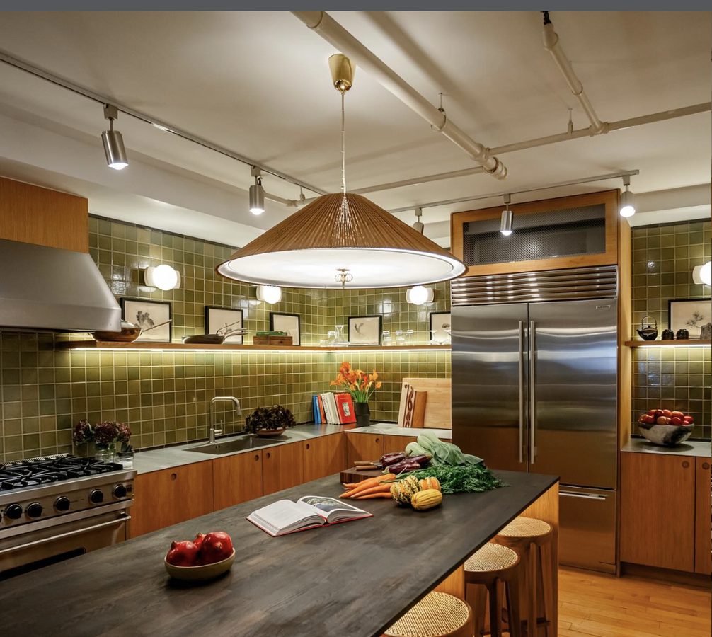 Industrial-style kitchen with butcher block island, green tile backsplash, and custom wood cabinets