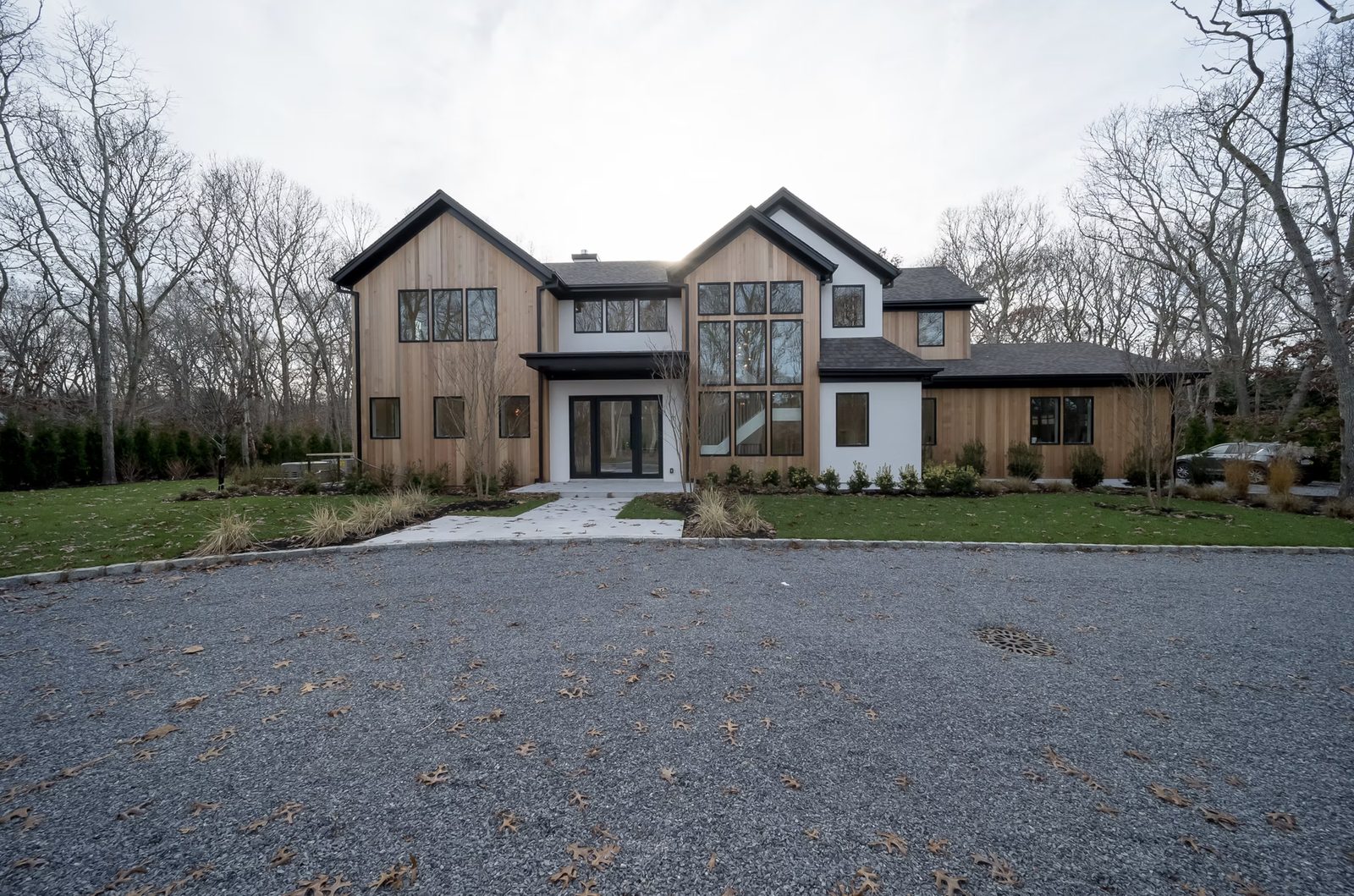 Front exterior of custom-built modern farmhouse with board-and-batten siding in East Hampton