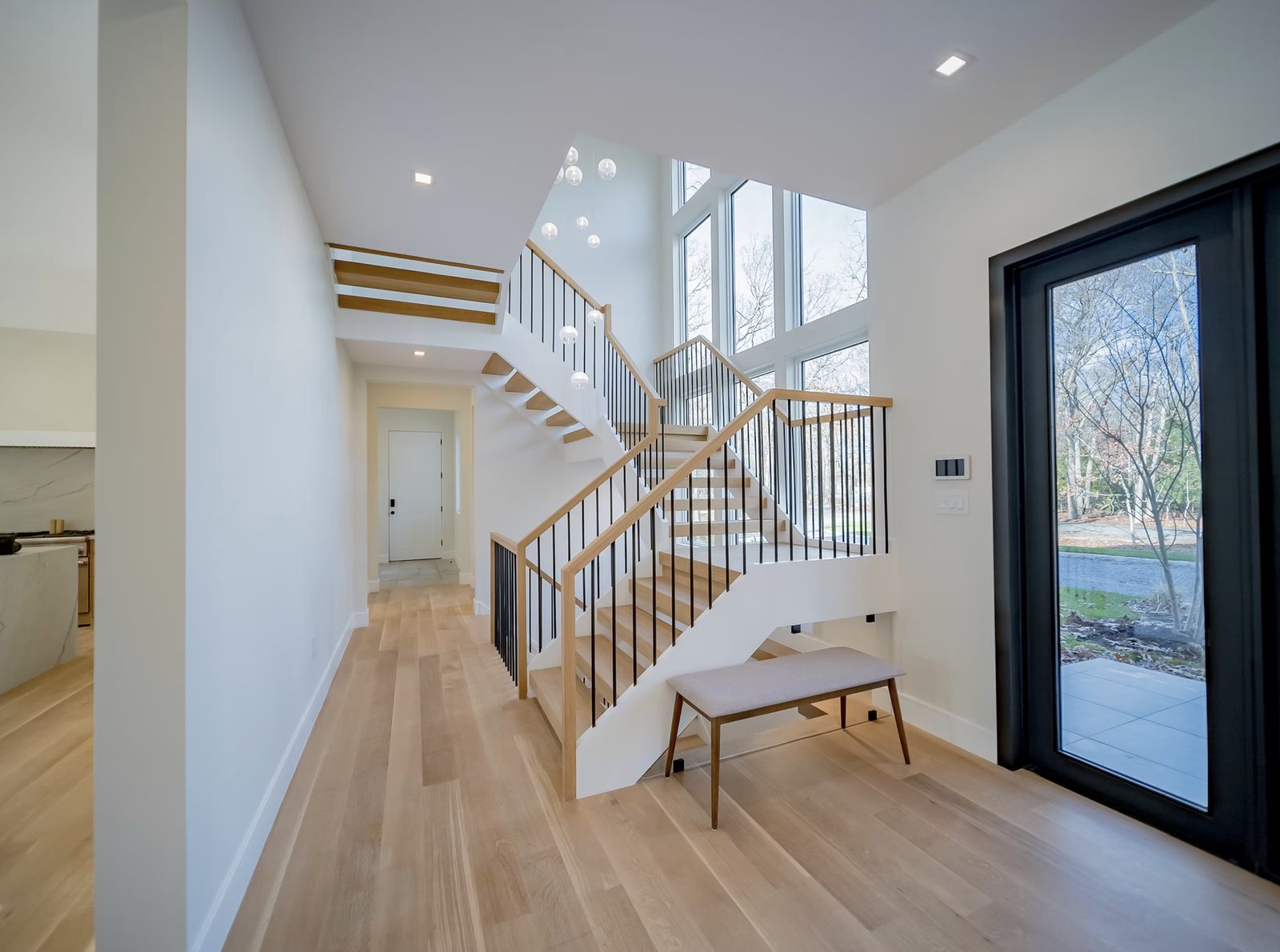 Custom staircase with turned wood balusters, stained handrail, and painted risers