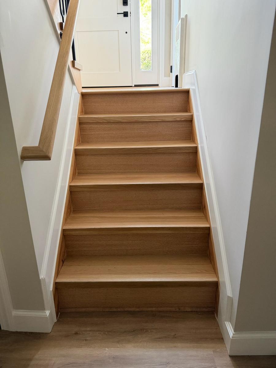 Finished oak staircase with white trim and oak handrail