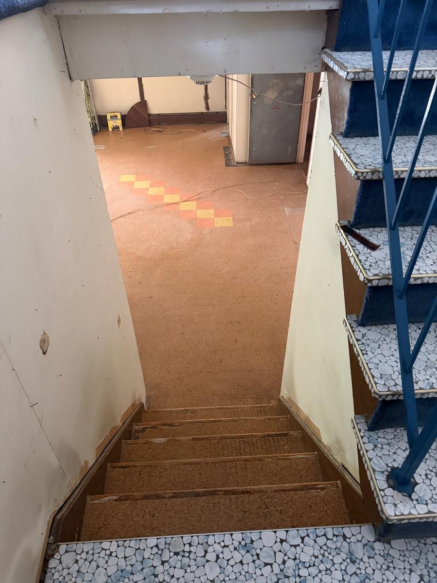 Old staircase before renovation with worn treads and dated railing